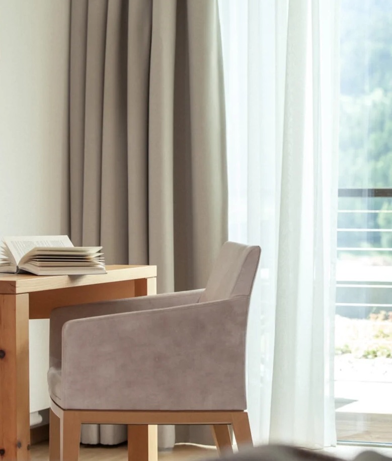 Sessel und Schreibtisch am Fenster eines Apartments