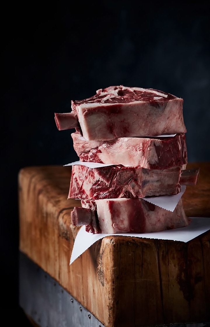 Gestapelte Steaks auf einem Holzblock